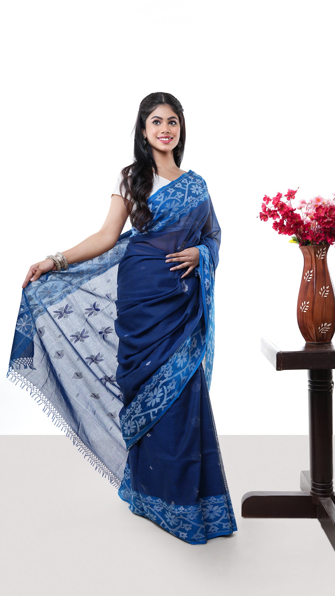 A dark and light blue saree. A dark blue coloured Tangail saree with light blue stripes. Crafted with soft cotton Warp and weft. Standard 5.5-meter length. Includes matching blouse piece. Tangail saree, cotton saree