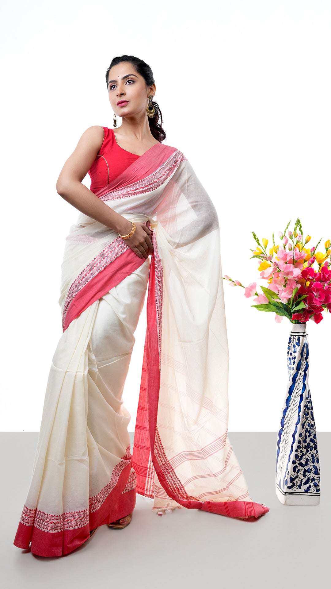 An off white and red tangail saree
