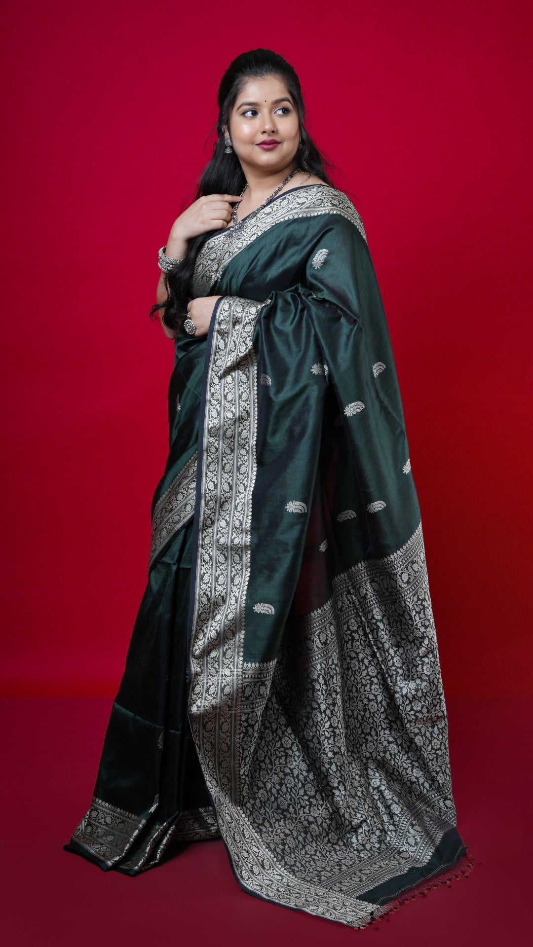 A bottle green coloured silk saree. A bottle green silk saree with minimal weave. Crafted with silk Warp and weft. Standard 5.5-meter length. Includes matching blouse piece. handloom silk sari