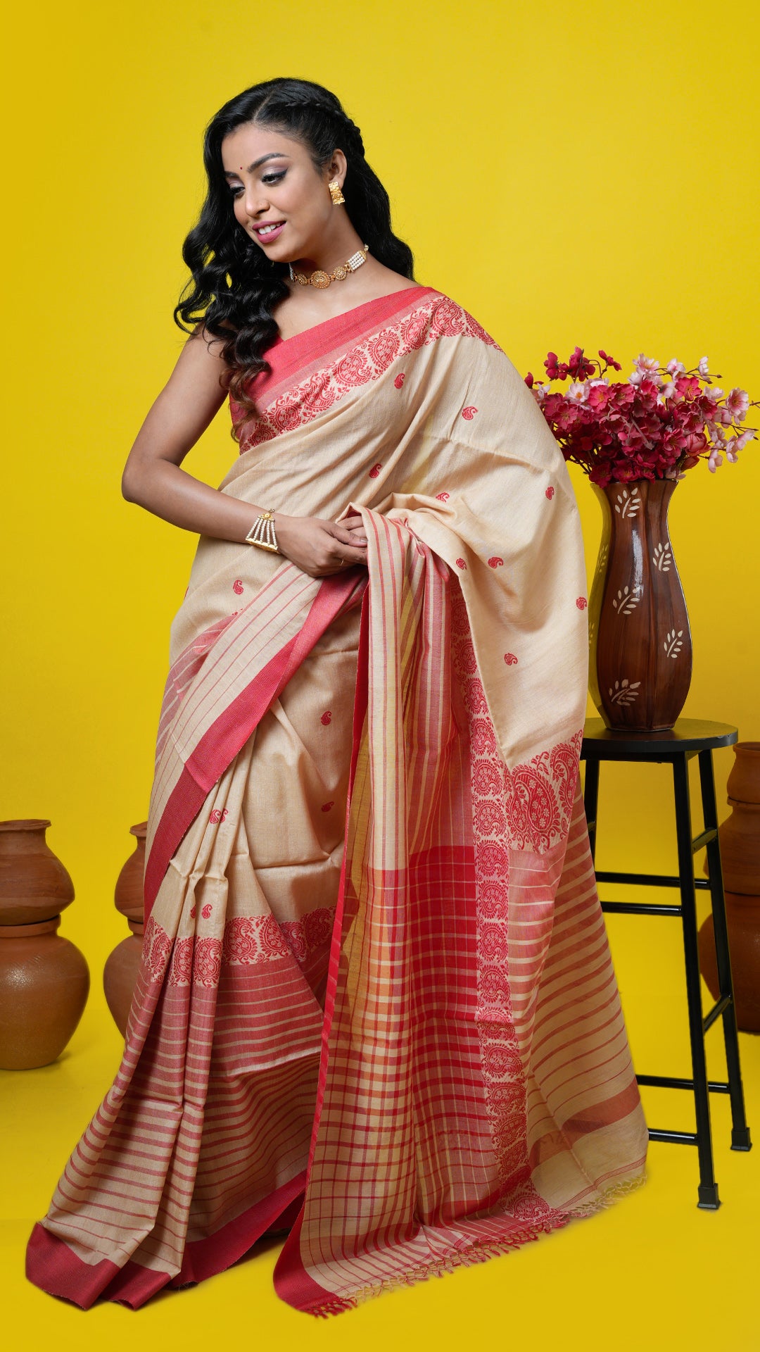 Natural-coloured Tassar saree with red weave, paisley butis, broad lower and short upper border. Price: Rs. 12,500/-
