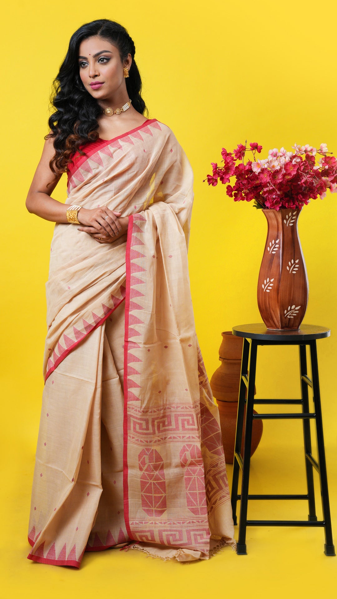 Beige soft cotton saree with red temple border, paisley pallu, and woven butis. Price: Rs. 5000/-