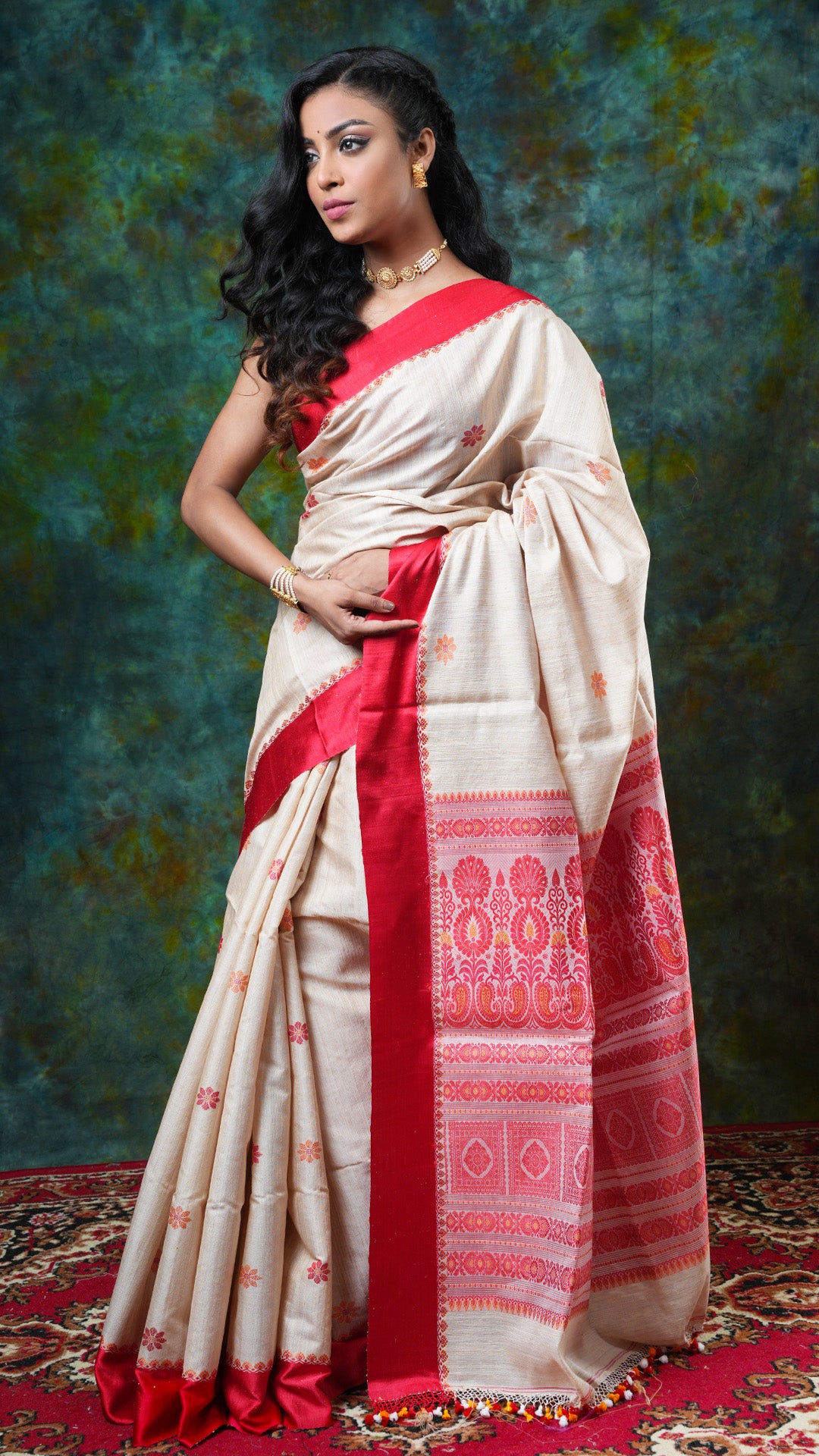 Beige raw silk Tangail saree with red satin border and orange motifs, red and orange woven pallu. Price: Rs. 21000/-