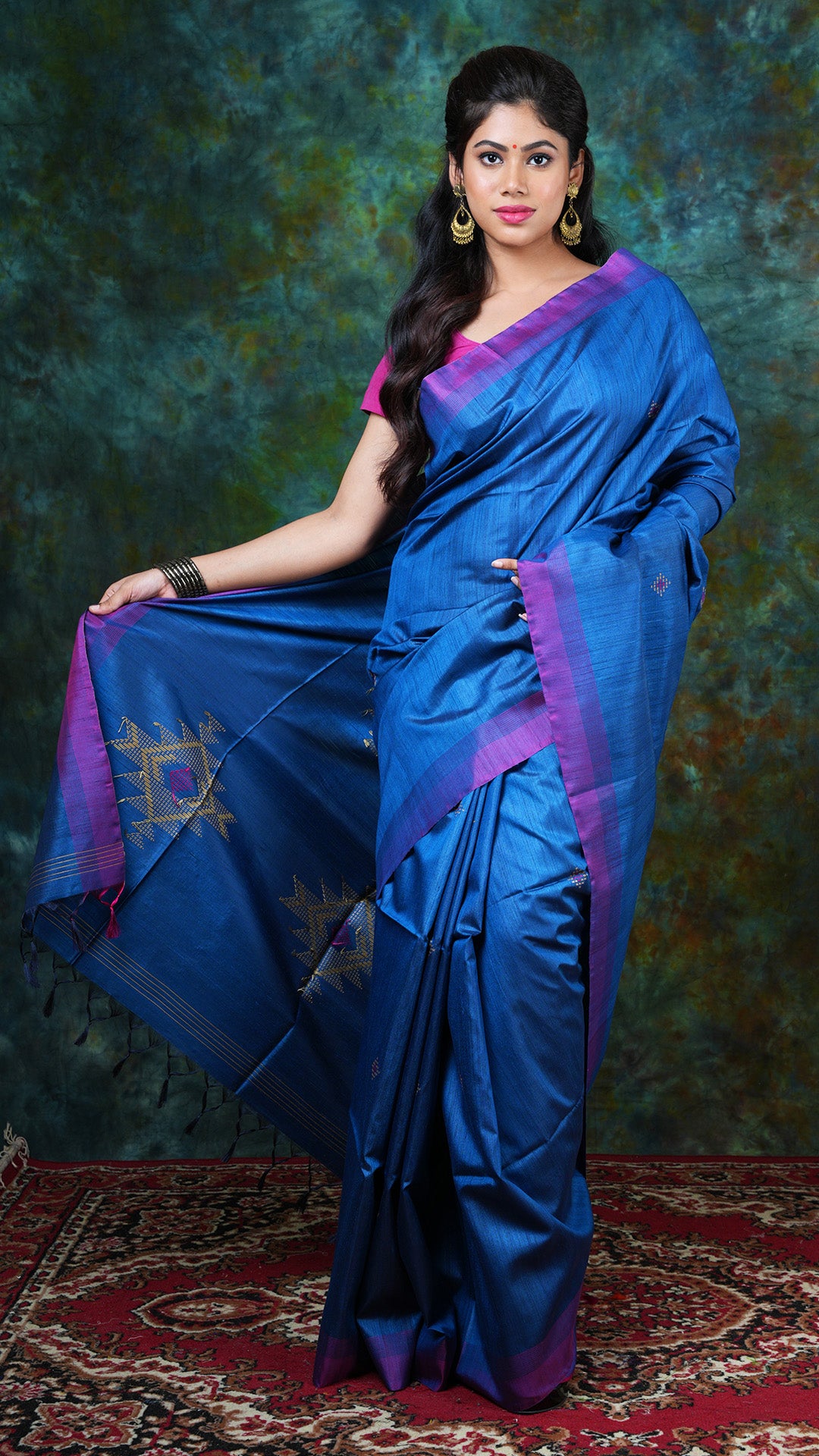 Blue Tassar Tangail saree with flat magenta border, butis and pallu woven in magenta and beige. Price: Rs. 9000/-
