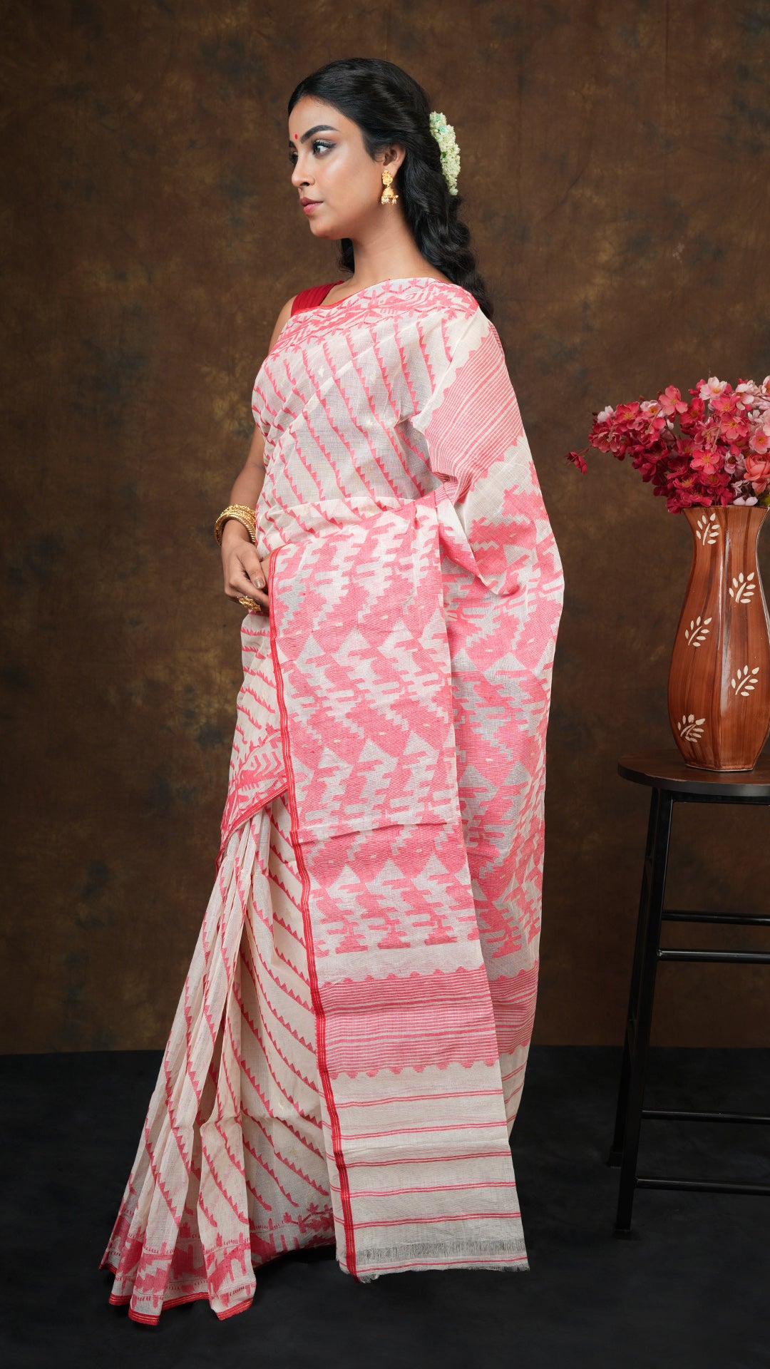 An off white and red jamdani saree