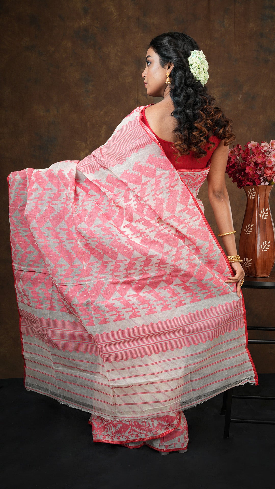 An off white and red jamdani saree