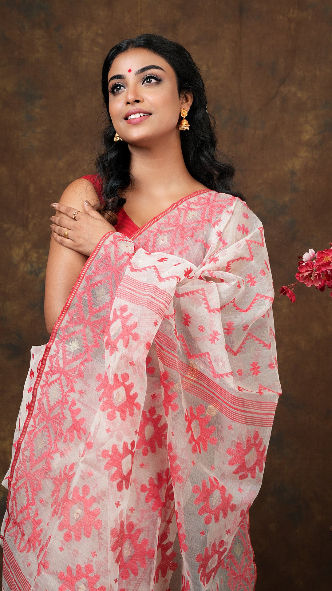 An off white and red muslin jamdani saree