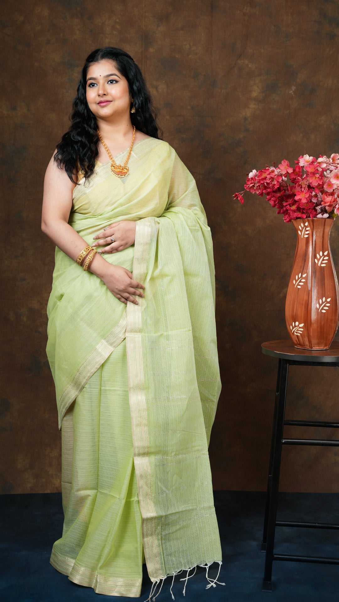 Light green soft cotton tangail saree with golden zari border and vertical striped pallu. No blouse piece. 5.5 meters.