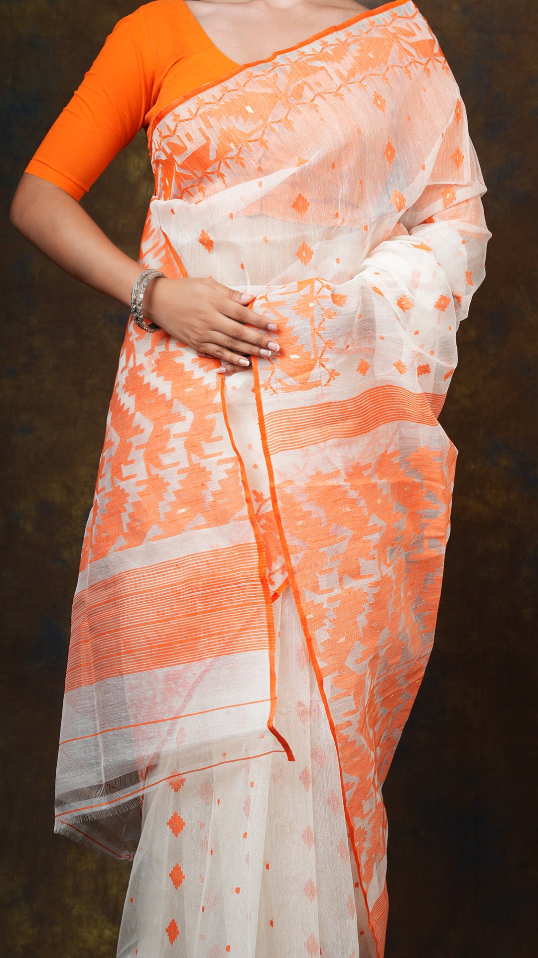 An off white and orange jamdani saree