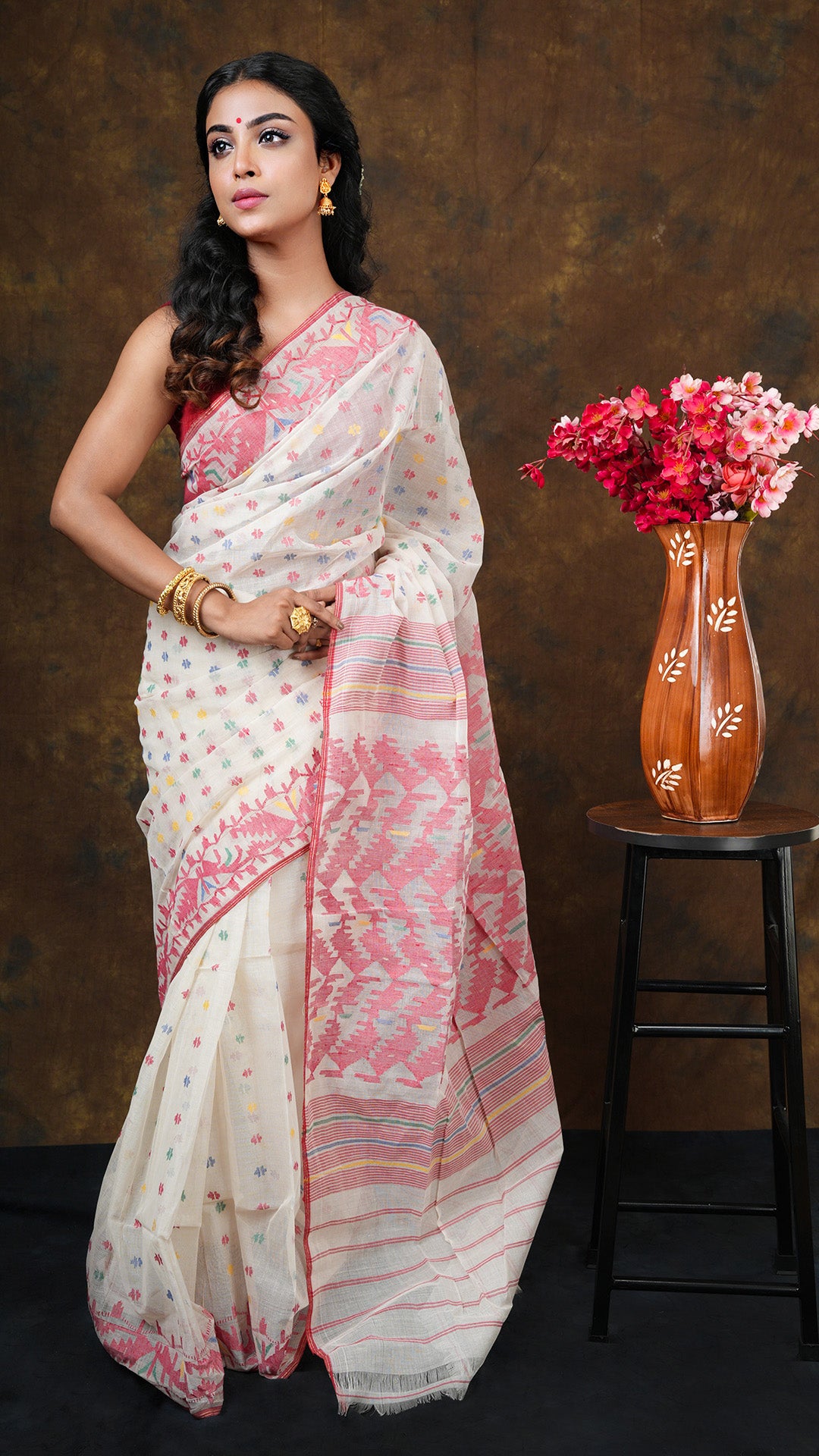 Off white -colored jamdani saree with red, blue, green, and yellow traditional weave. Includes 0.8m separate blouse piece. 5.5 meters.