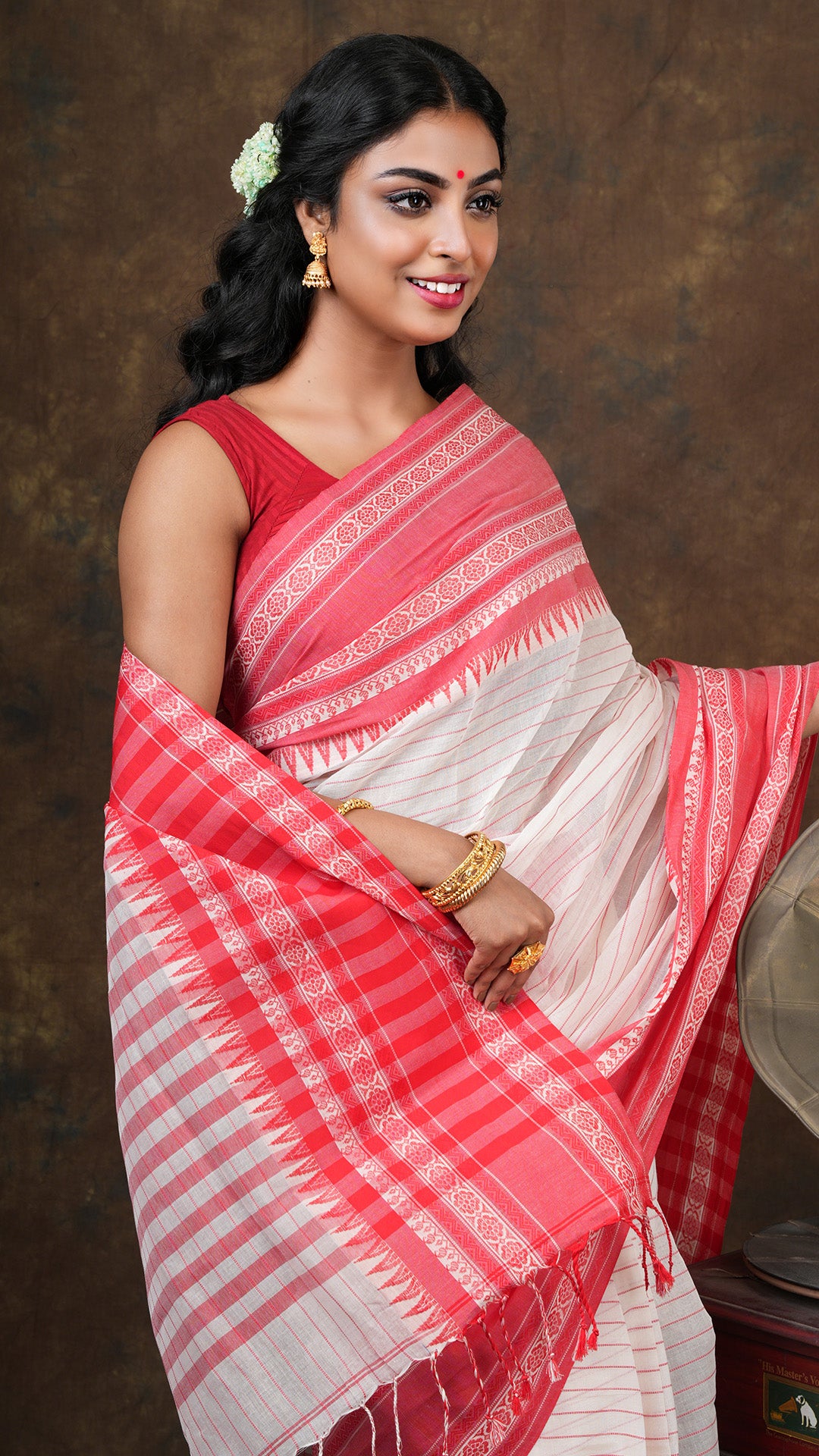 An off white and red tangail saree