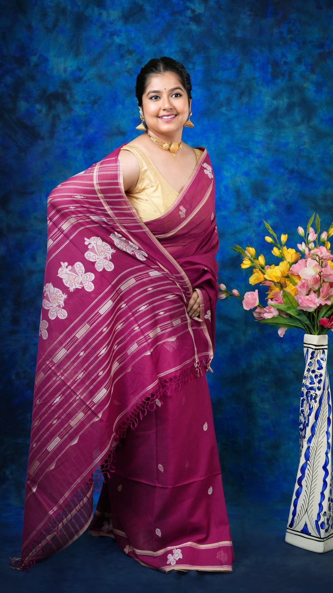 A magenta tangail saree - A soft cotton magenta tangail saree with off-white and beige woven butis and pallu. This elegant Tangail saree is perfect for classic traditional looks.