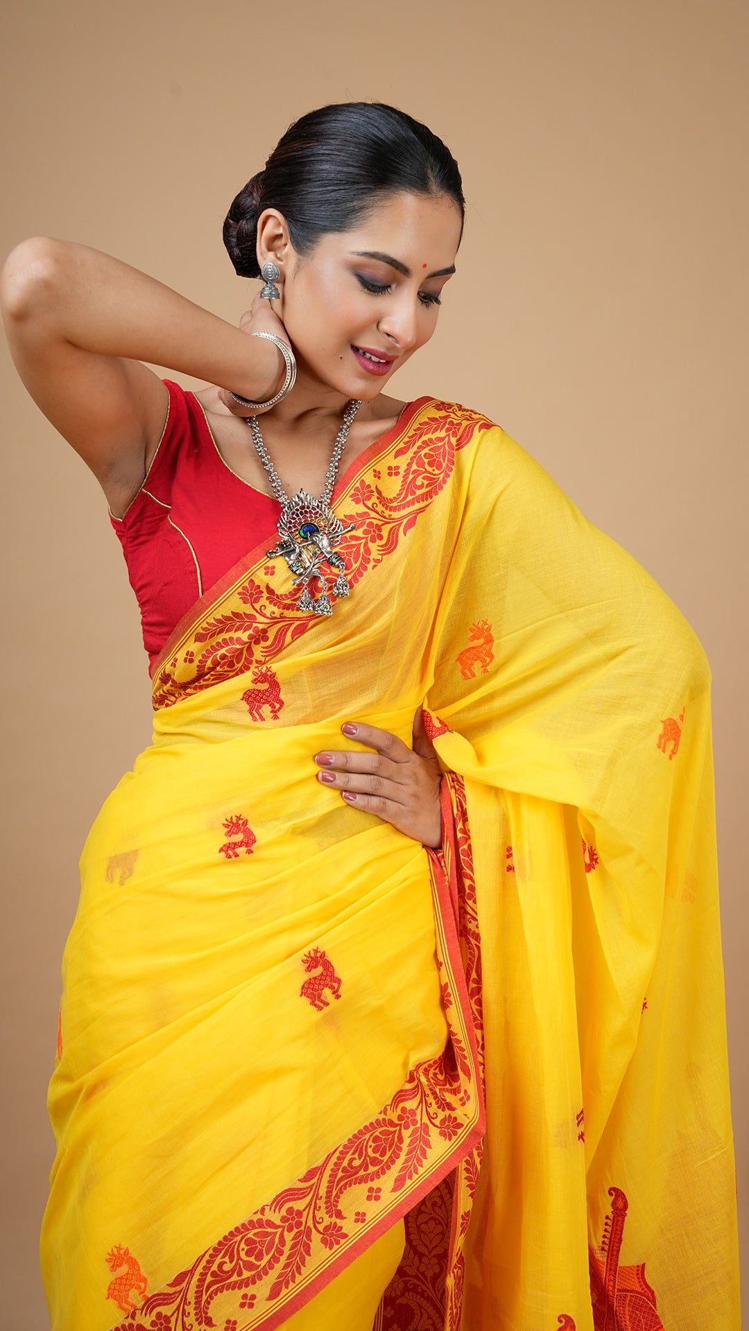 A bright yellow tangail saree