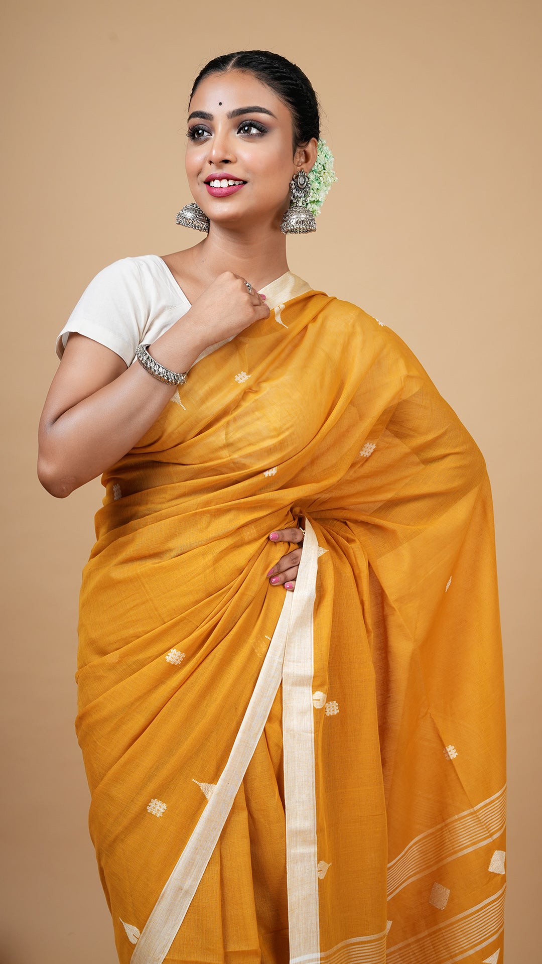 A mustard coloured dhakai saree