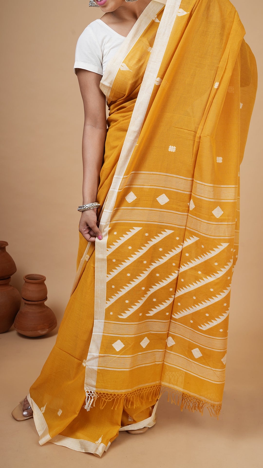 A mustard coloured dhakai saree