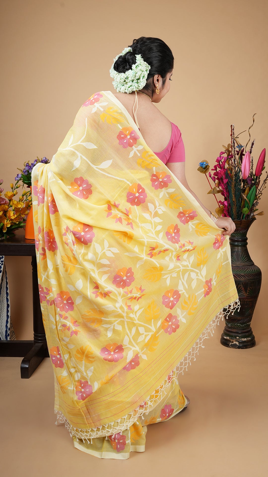Lemon yellow soft cotton dhakai saree with floral weave in white, magenta, mustard and pink across body, border and pallu.