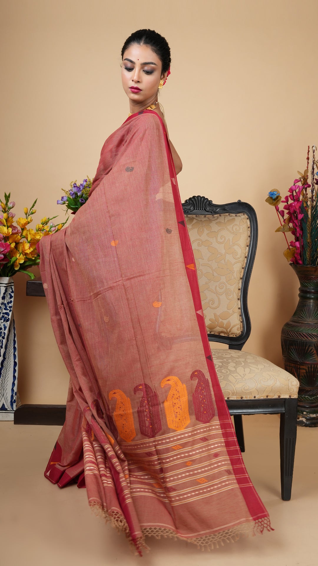 Light maroon Tangail soft cotton saree with dark maroon border, woven butis and pallu in mustard, off-white, maroon, and green. Ideal for puja and traditional gatherings.
