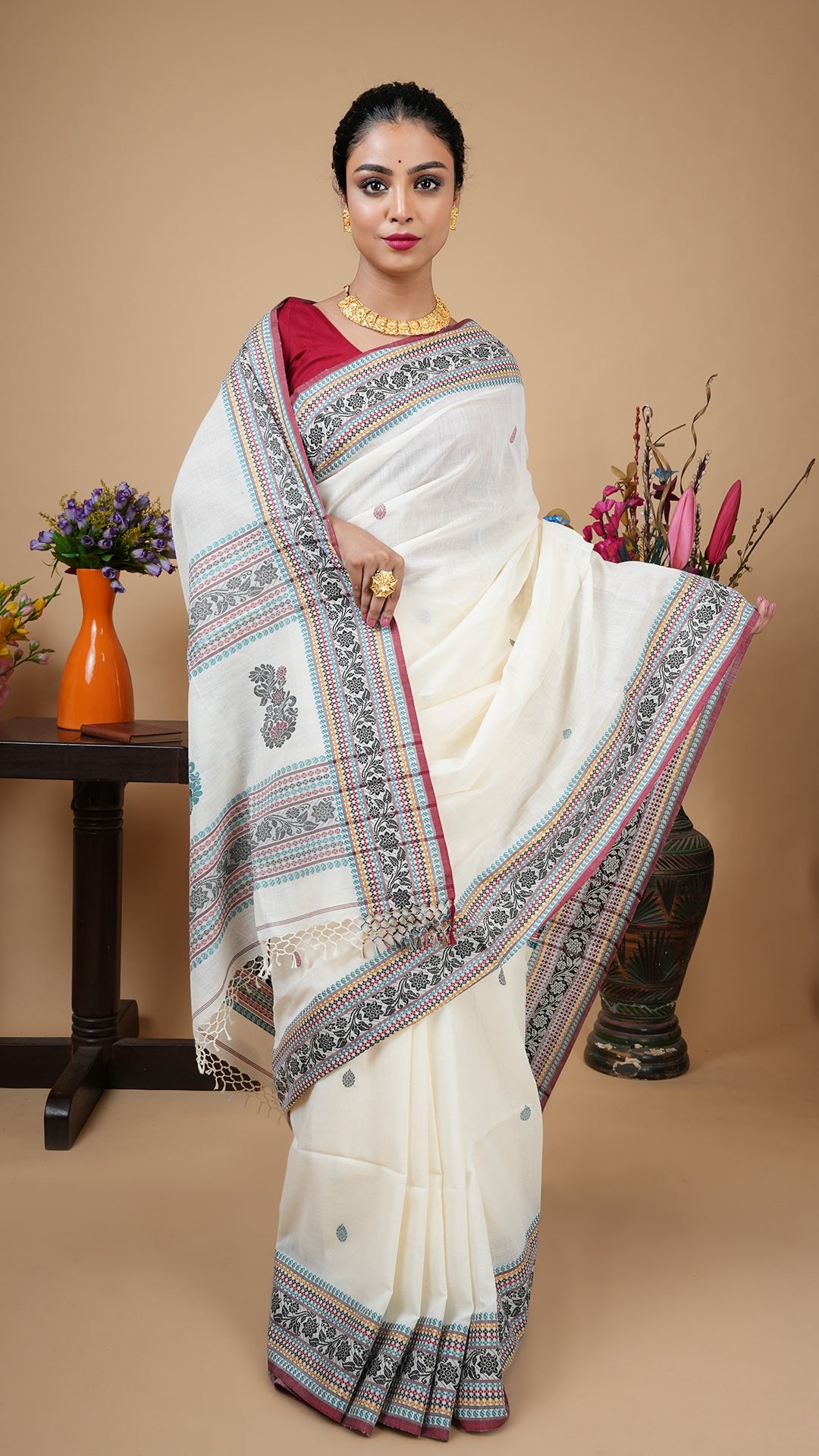 Off-white Tangail soft cotton saree with traditional woven border, butis, and pallu in black, maroon, sea green, and beige. Versatile ethnic wear for office, casual, or festive use.