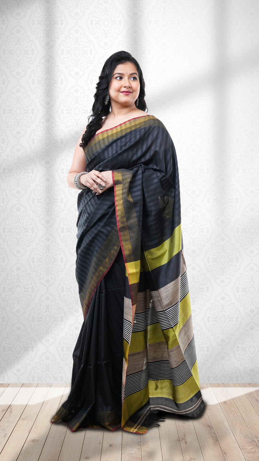 A black silk saree. A black Tangail saree silk saree with self stripes. The pallu is deep green and black. Crafted with silk Warp and weft. Standard 5.5-meter length. Includes matching blouse piece. Tangail saree, handloom silk sari.
