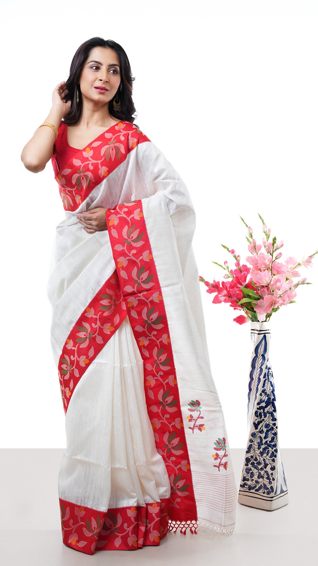 An off white with red raw silk. An off white and red sari with minimal weaving. Crafted with muslin silk Warp and raw silk weft. Standard 5.5-meter length. Includes matching blouse piece. handloom silk sari