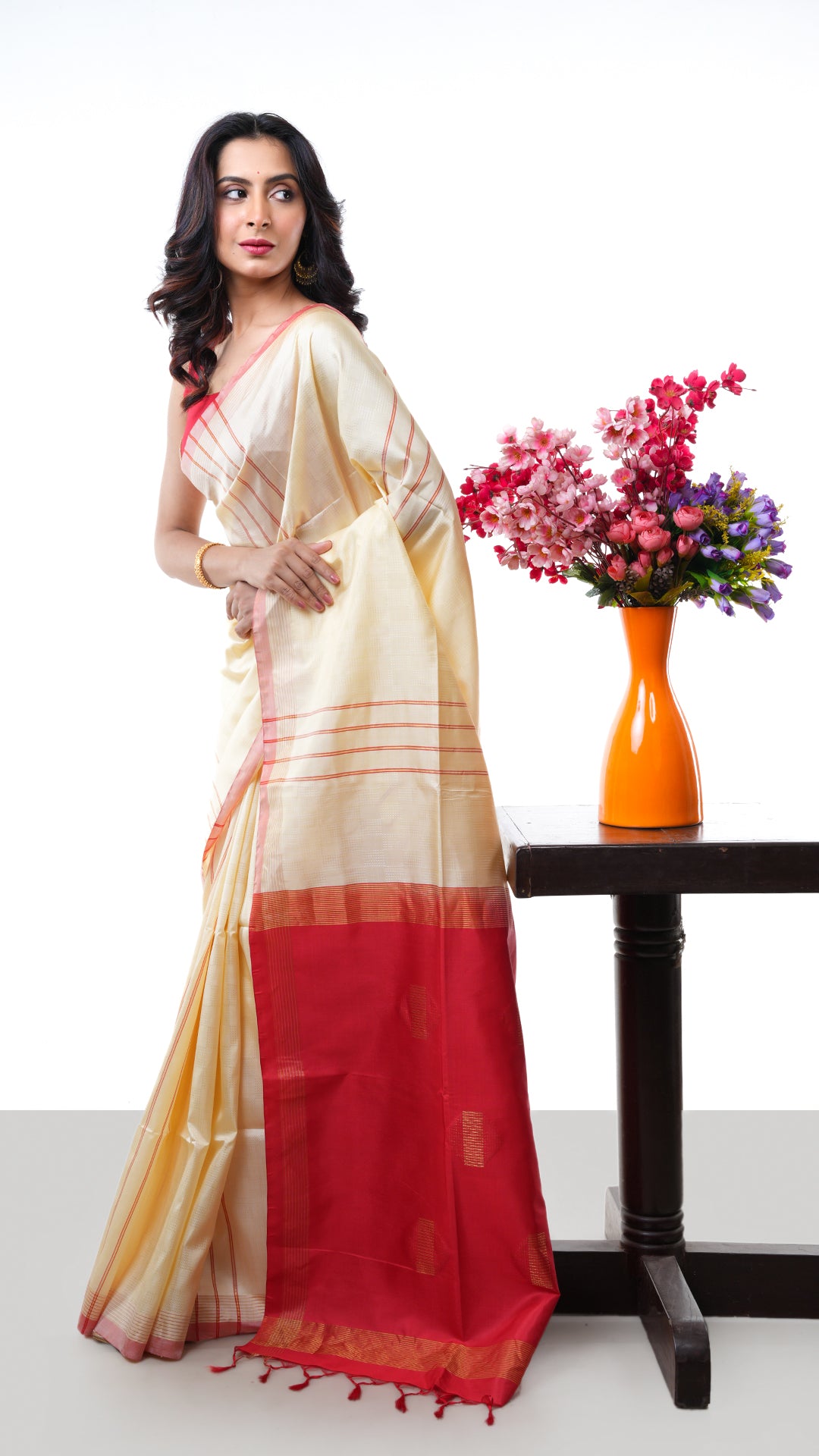 An off white red silk saree. A silk sari with red accents and soft sheen. Crafted with silk Warp and weft. Standard 5.5-meter length. Includes matching blouse piece. handloom silk saree
