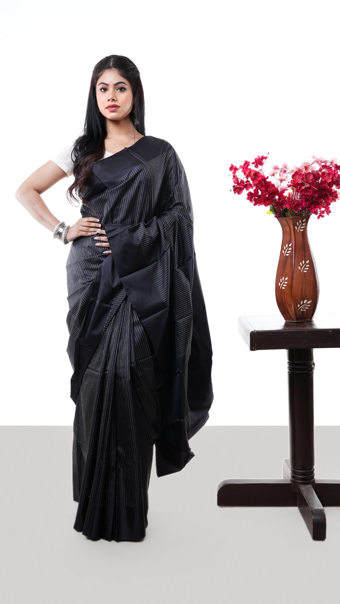 A black silk saree. A black coloured silk saree with a glossy texture. Crafted with silk Warp and weft. Standard 5.5-meter length. Includes matching blouse piece. handloom silk sari
