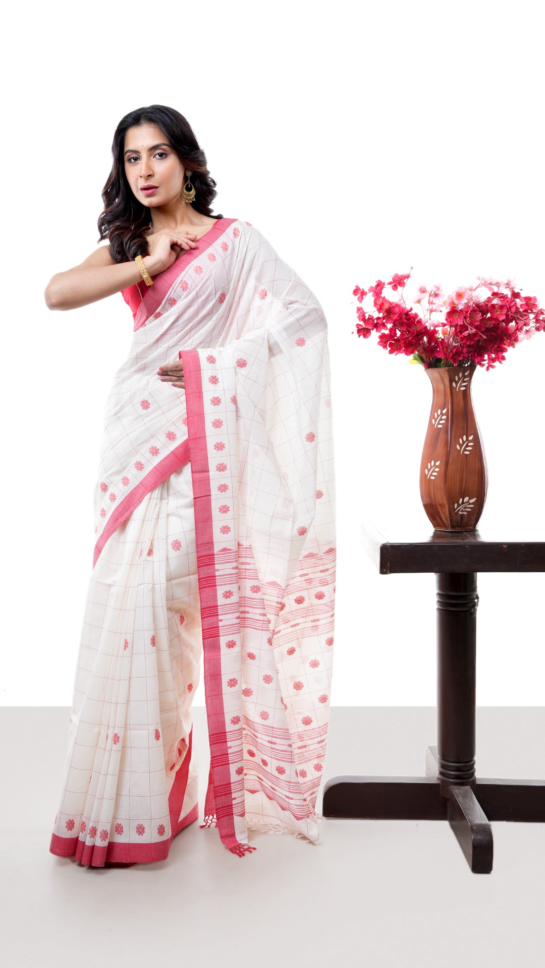 An off white red cotton saree. An off white cotton sari with red temple border. Crafted with cotton Warp and weft. Standard 5.5-meter length. Includes matching blouse piece. cotton saree