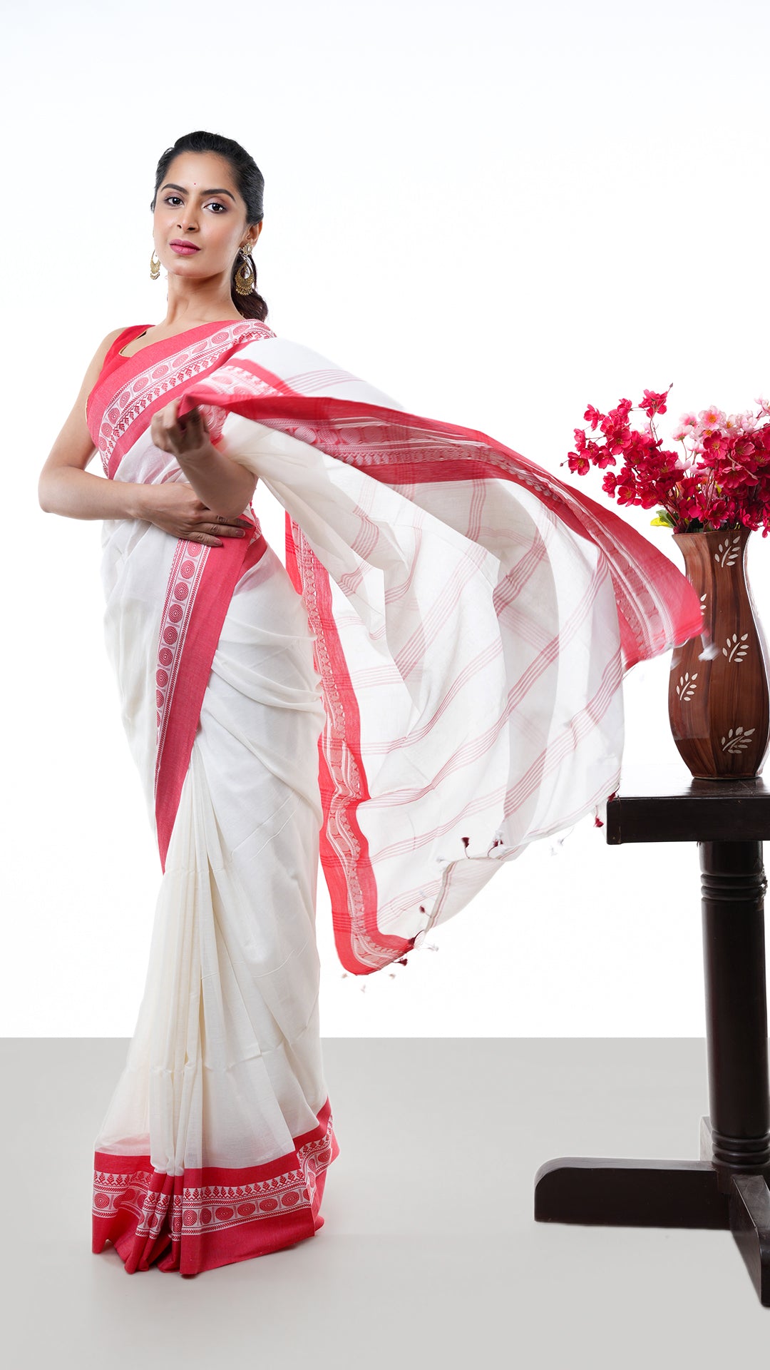 An off white and red Tangail saree. A Tangail saree in off white base and red border. Crafted with soft cotton Warp and weft. Standard 5.5-meter length. Includes matching blouse piece. Tangail saree, cotton saree