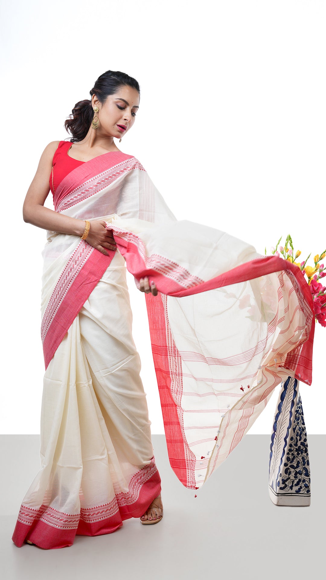 An off white and red Tangail saree. A Tangail saree with classic off white body and bold red border. Crafted with soft cotton Warp and weft. Standard 5.5-meter length. Includes matching blouse piece. Tangail saree, cotton saree