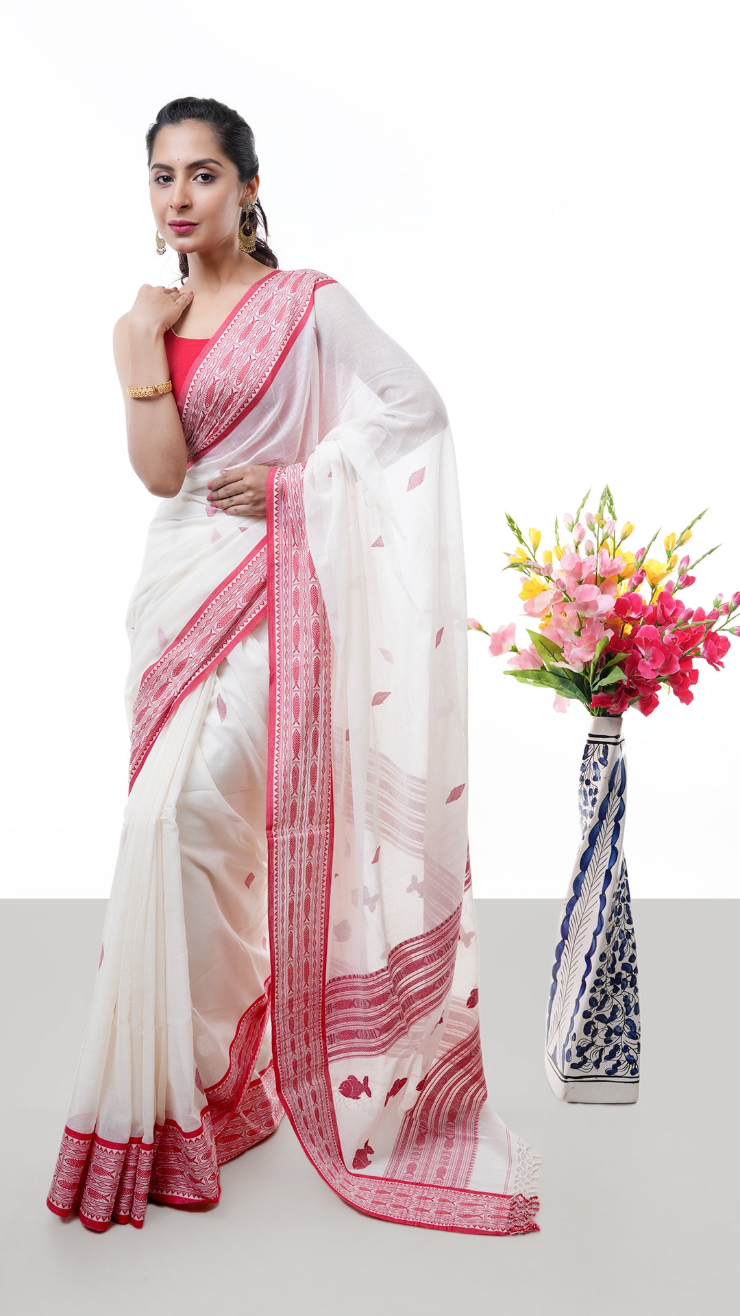 An off white and red Tangail saree. A Tangail saree with temple border and vibrant red pallu. Crafted with soft cotton Warp and weft. Standard 5.5-meter length. Includes matching blouse piece. Tangail saree, cotton saree
