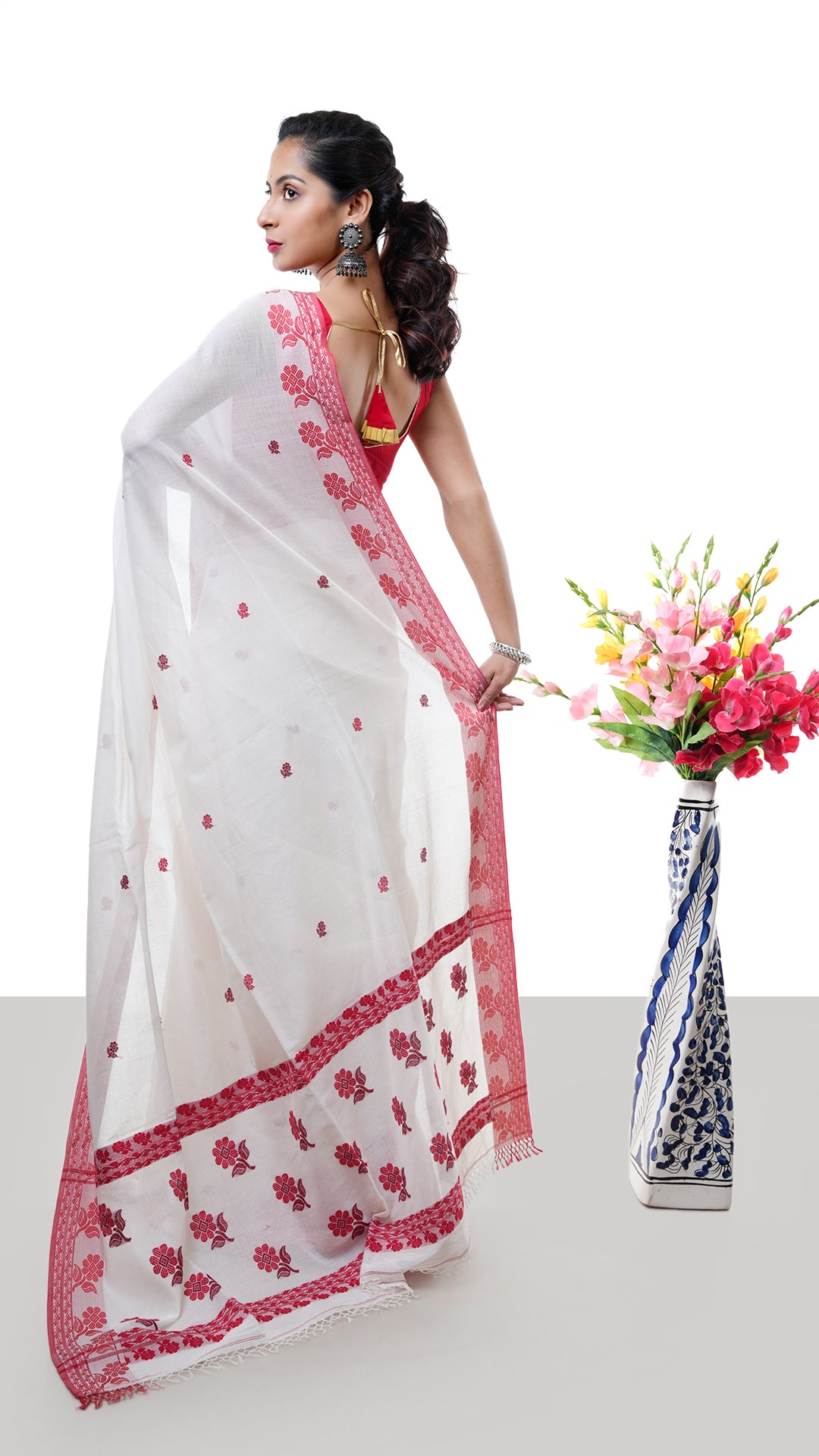 An off white and red tangail saree