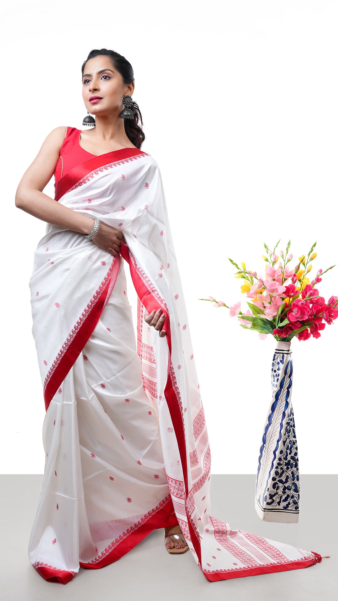 An off white red silk saree. A Tangail saree in silk saree with minimal red border. Crafted with silk Warp and weft. Standard 5.5-meter length. Includes matching blouse piece. Tangail saree, handloom silk sari