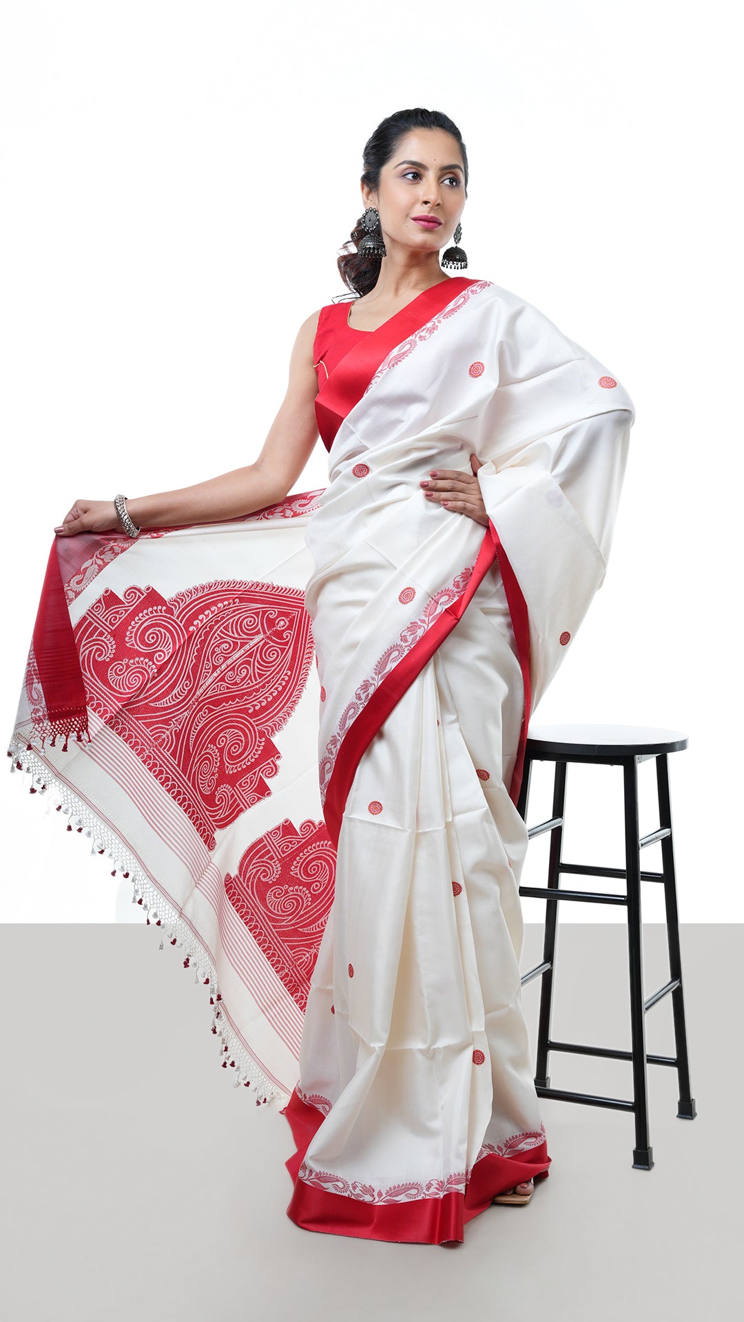 A silk saree in off white and red. A Tangail saree with festive tones in silk. Crafted with silk Warp and weft. Standard 5.5-meter length. Includes matching blouse piece. Tangail saree, handloom silk saree