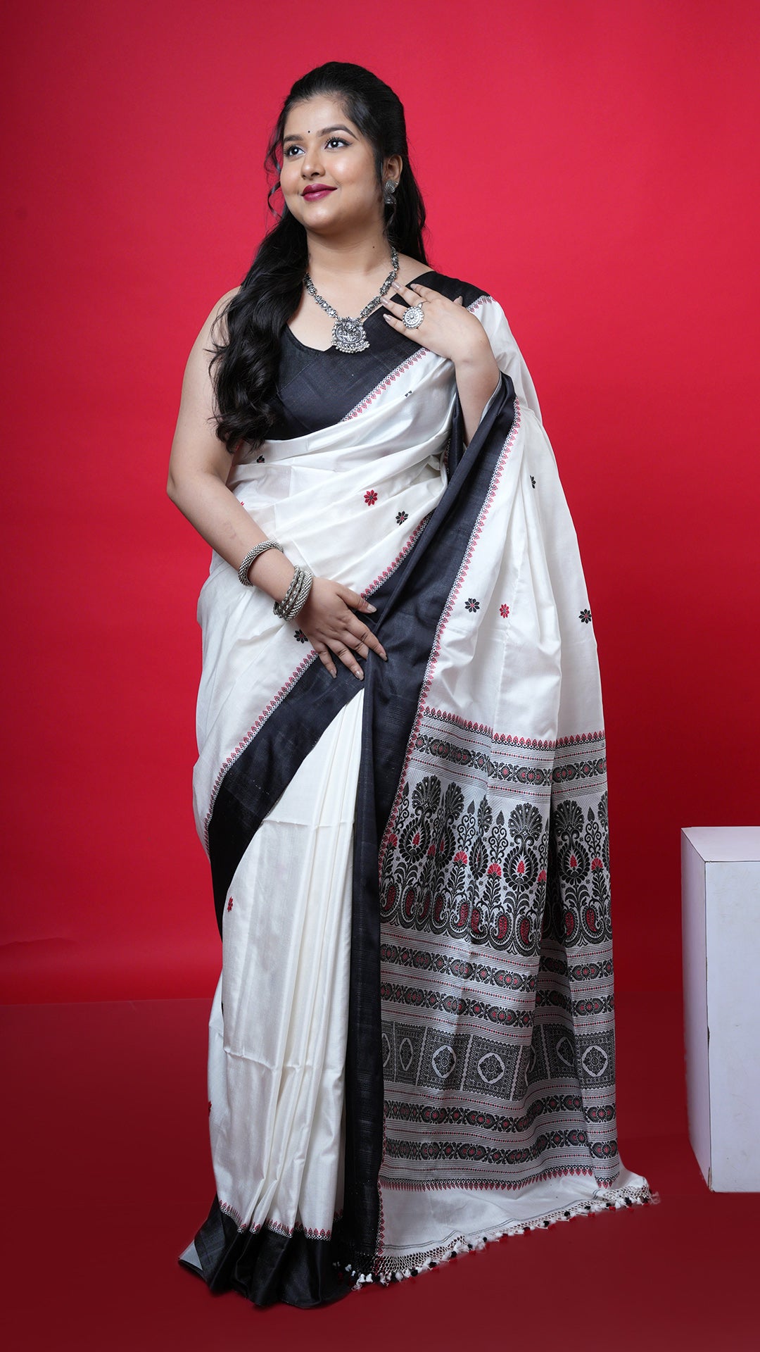 An off white with black and red silk. An off white silk saree with black border and red pallu. Crafted with silk Warp and weft. Standard 5.5-meter length. Includes matching blouse piece. handloom silk sari