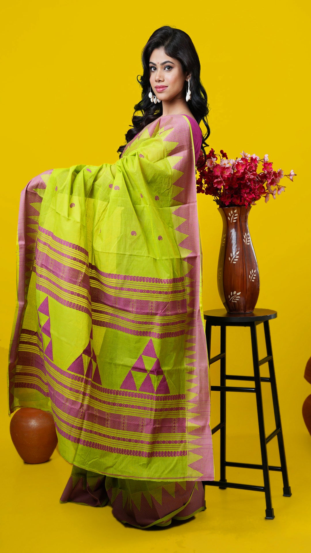 Green cotton Tangail saree with magenta temple border, butis and pallu also in magenta. Price: Rs. 2,600/-