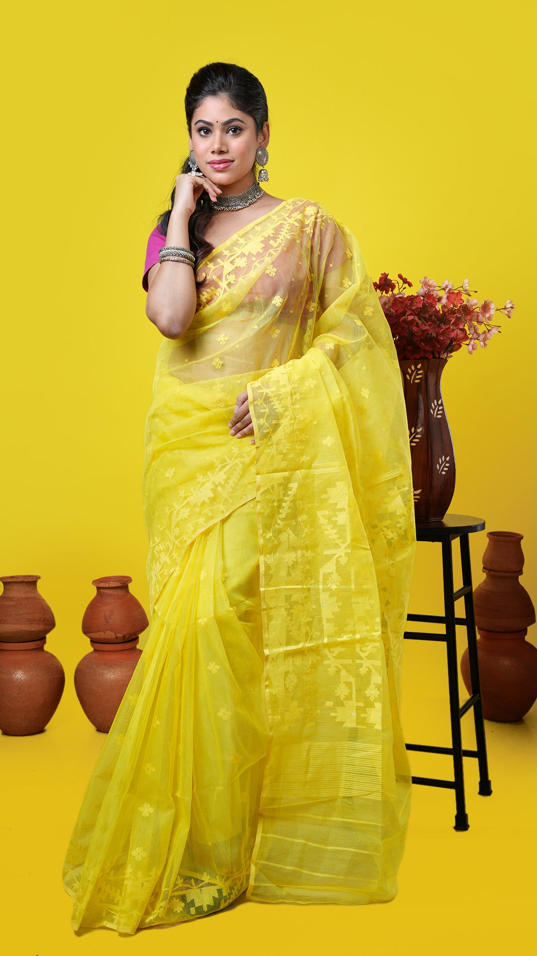 Yellow muslin jamdani saree with self-woven border, butis, and pallu. Price: Rs. 11,500/-