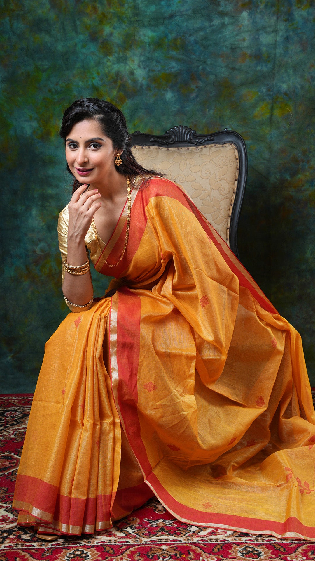 Golden yellow tissue saree with flat red border, red woven butis and pallu. Price: Rs. 2800/-