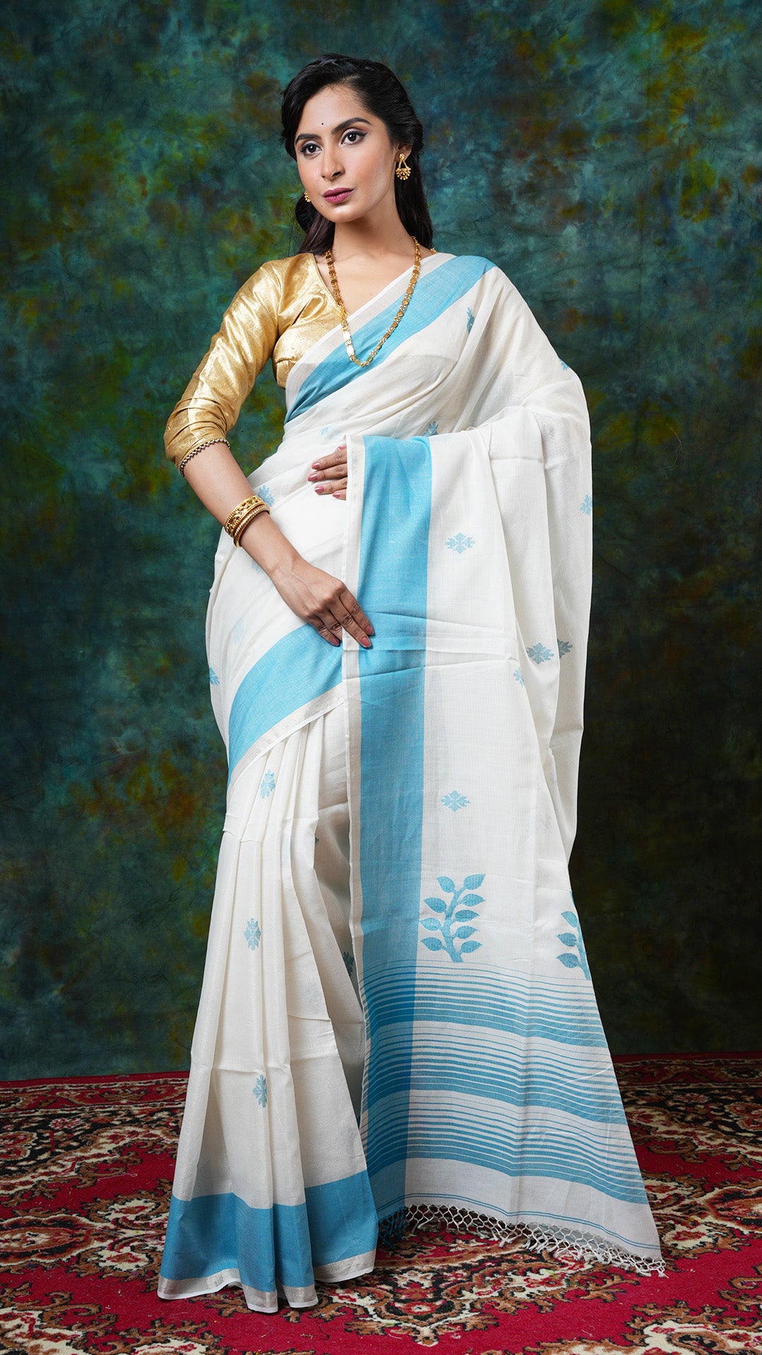 Off-white tissue saree with flat blue border and blue woven butis and pallu. Price: Rs. 2800/-