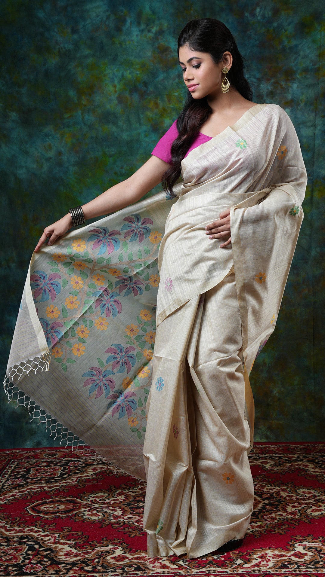 Dark off-white raw silk saree with tassar border, muslin silk pallu, multicolor dhakai butis and pallu. Price: Rs. 15000/-