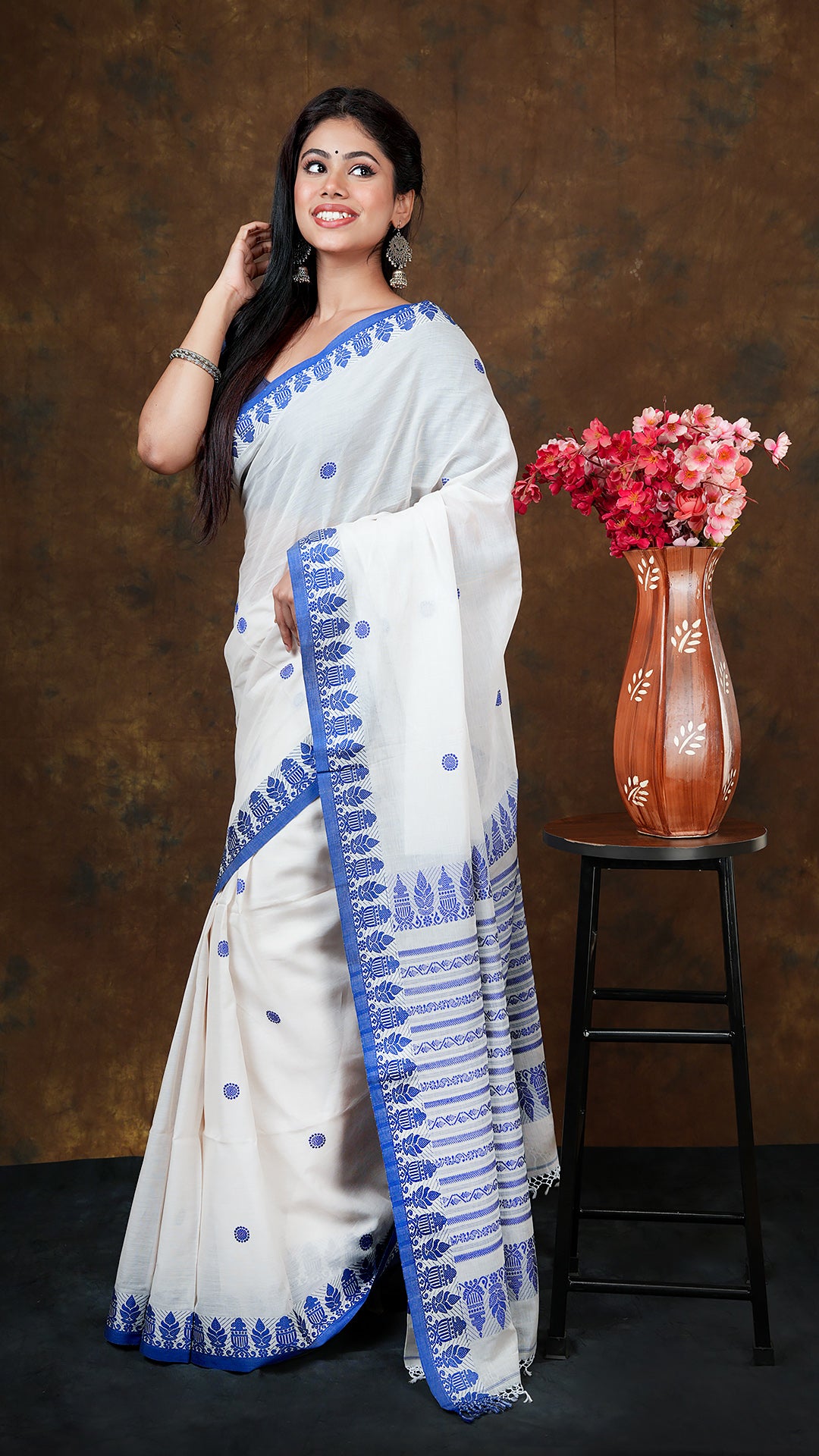 Off white with blue tangail - A soft cotton tangail saree in off-white with blue border detailing. This elegant Tangail saree, soft cotton saree is perfect for traditional occasions.