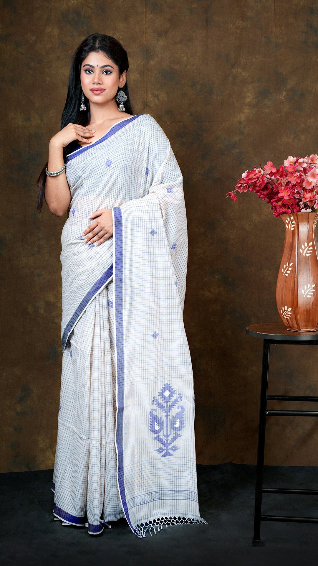 An off white with blue check saree - A tangail style checkered saree in off white and blue hues. This elegant Tangail saree, soft cotton saree is perfect for traditional occasions.