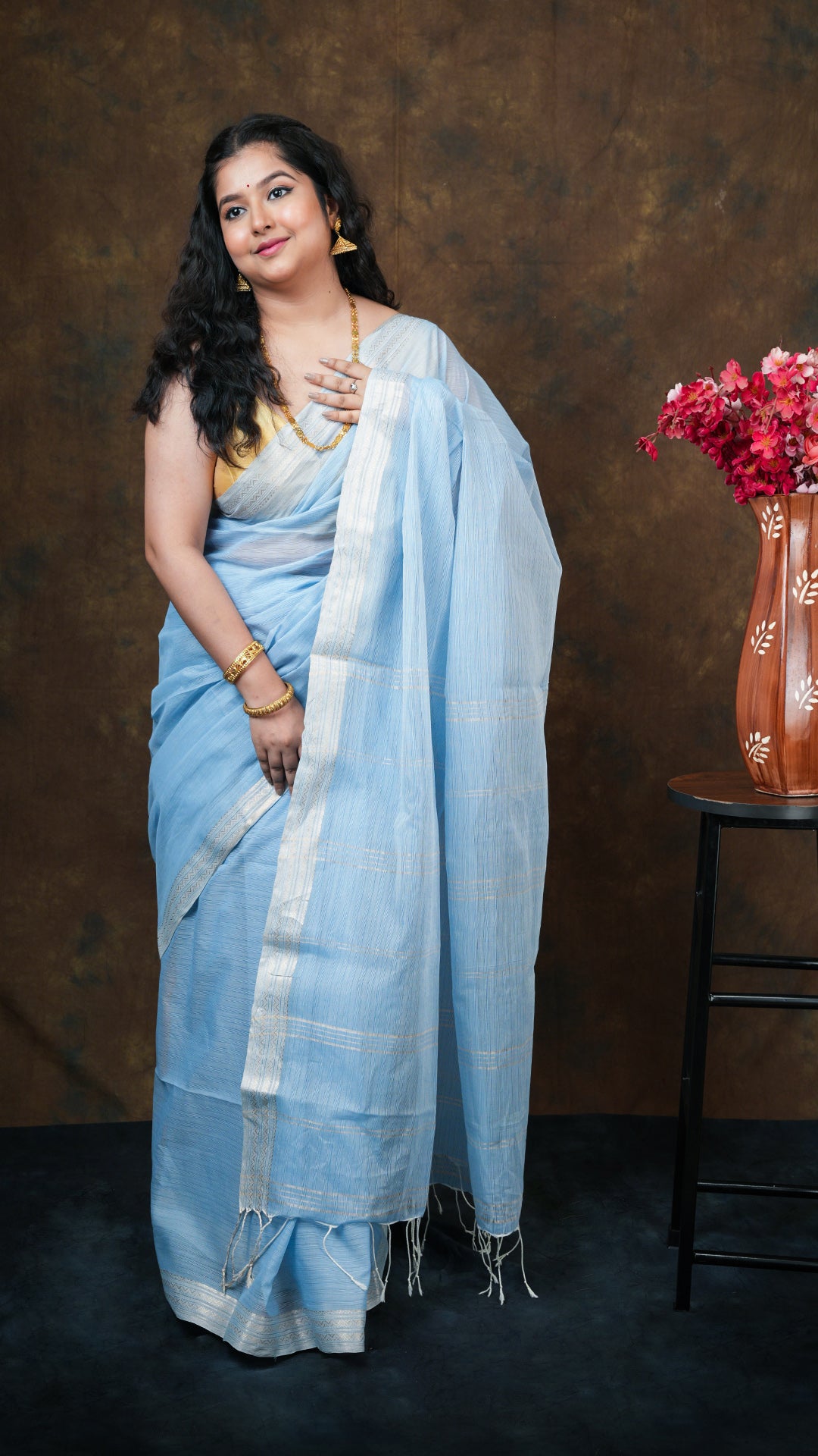 Sky blue soft cotton tangail saree with golden zari border and vertical striped pallu. Handwoven in traditional jaquard style. 5.5 meters long