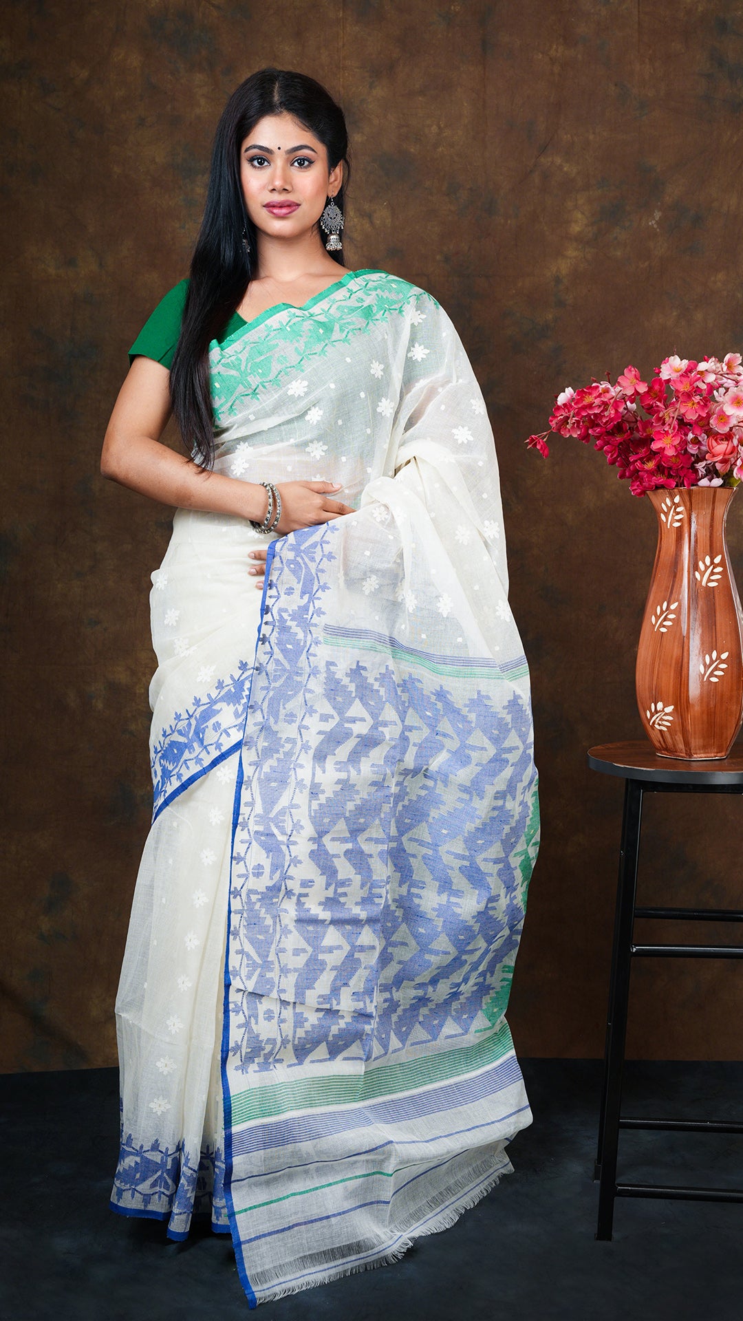 Off white cotton jamdani saree with ganga-jamuna blue-green borders and pallu. Features off white butis. 5.5 meters with separate blouse piece.