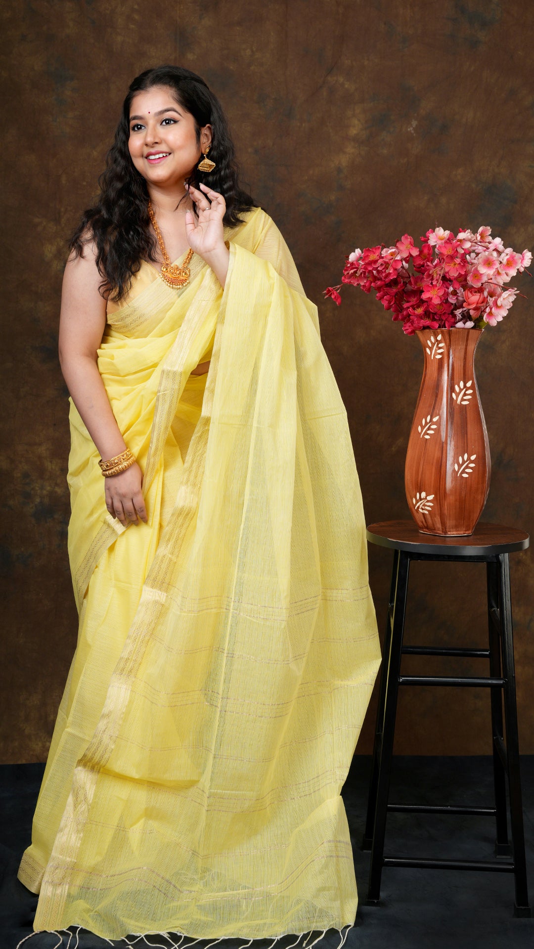 Lemon yellow soft cotton tangail saree with golden zari border and vertical striped pallu. 5.5 meters long