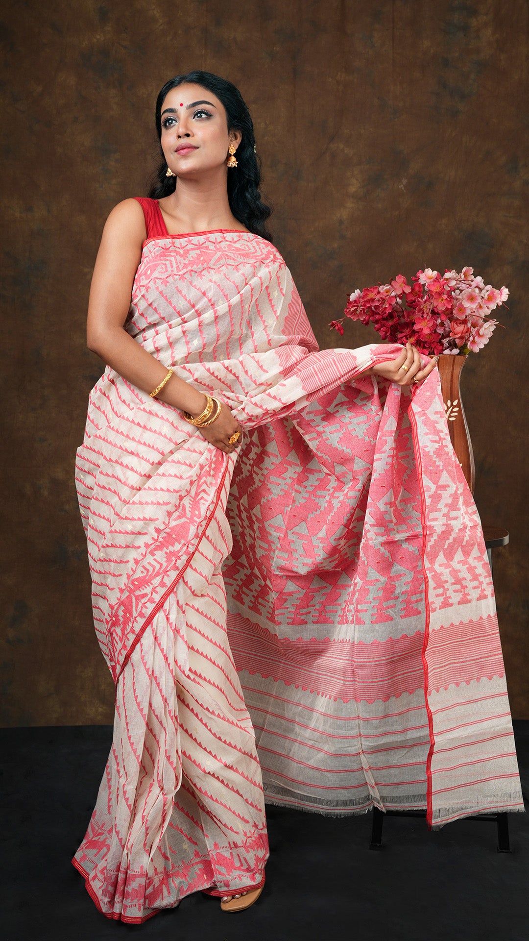 Traditional off white cotton jamdani saree with red and golden zari diagonal weave. Includes 0.8m separate blouse piece. 5.5 meters.