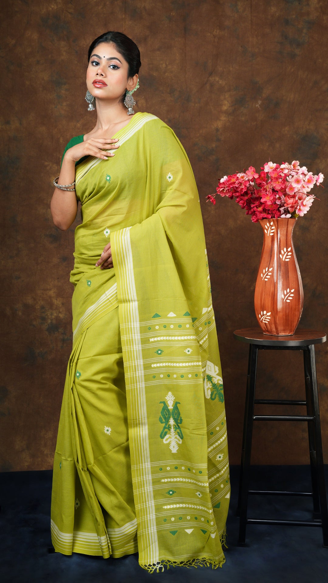 Green soft cotton tangail saree with white striped border and dark green-white pallu. Includes 0.8m running blouse piece. 5.5 meters.