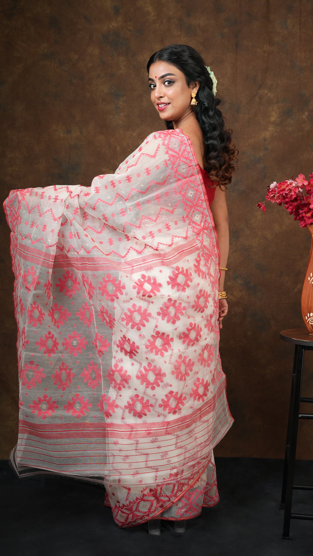An off white and red muslin jamdani saree