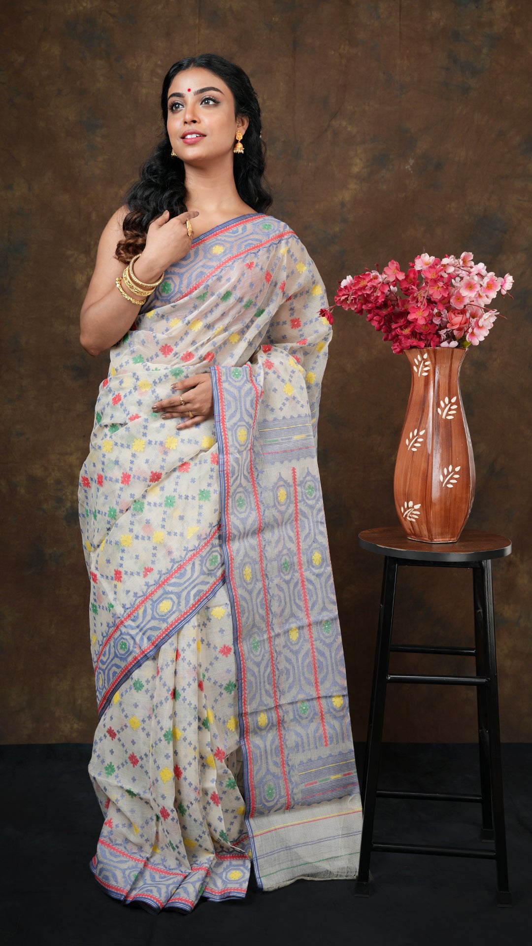 Multi-colored cotton jamdani saree in off white with blue, red, yellow, and green jaal weave. Includes 0.8m separate blouse piece. 5.5 meters