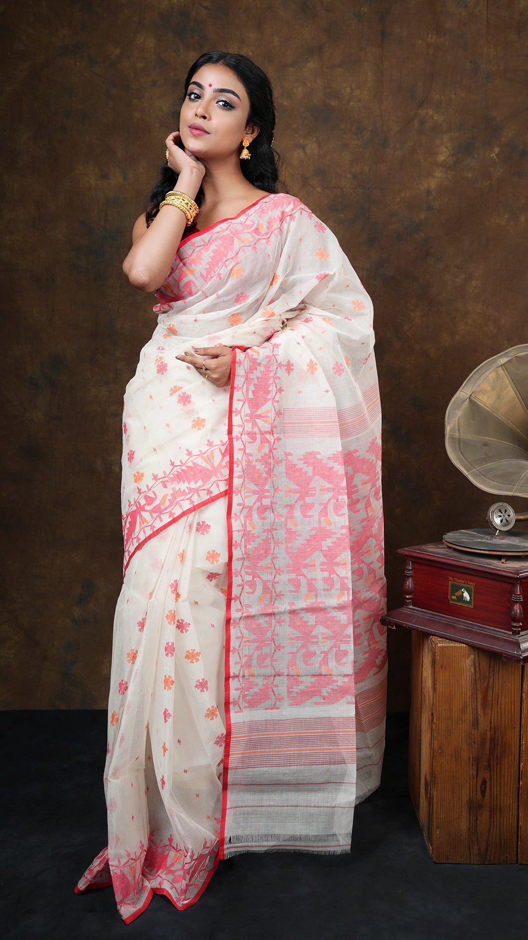 Off white cotton jamdani saree with red and orange traditional weave. Includes 0.8m separate blouse piece. 5.5 meters