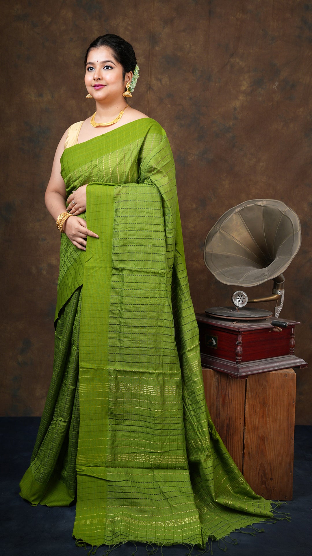 Green silk and mercerized cotton tangail saree with all-over missed checks and flat-woven border. Traditional jaquard weave. 5.5 meters