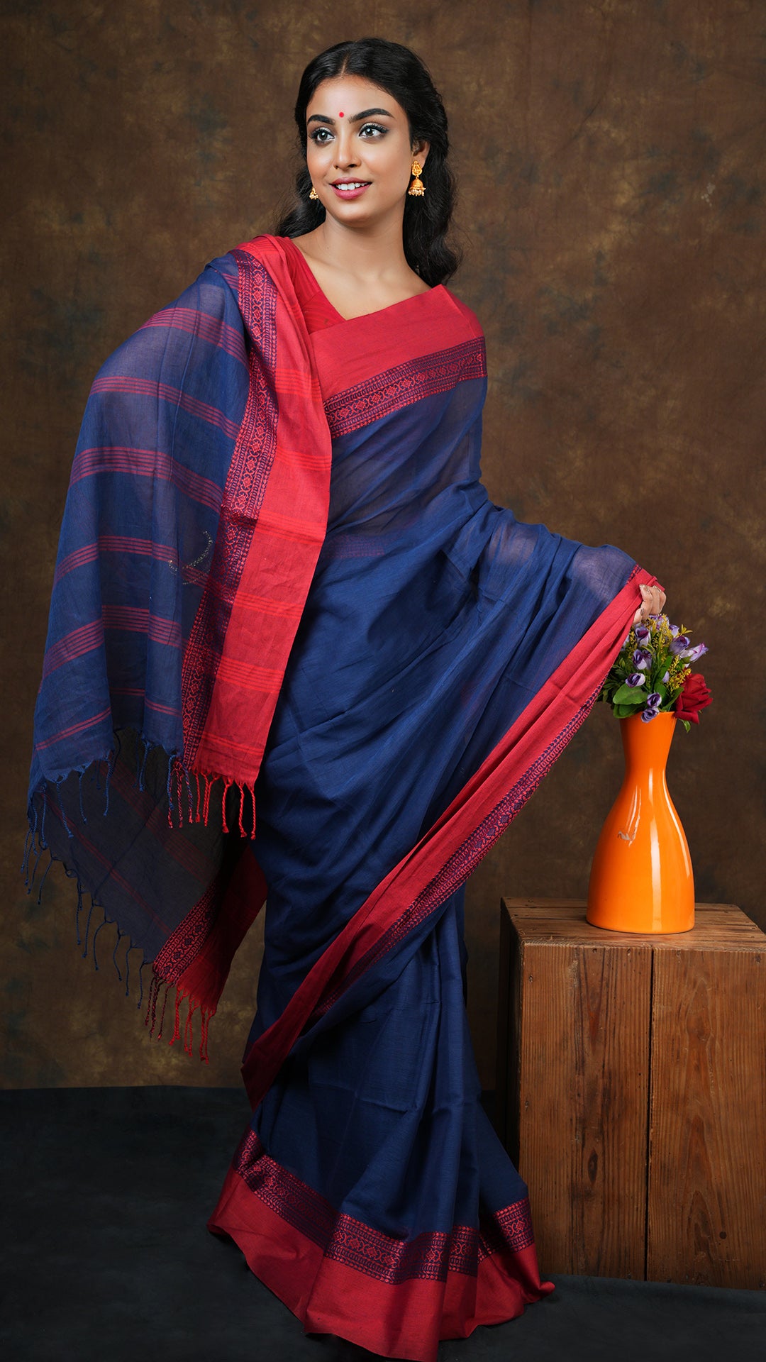 Navy blue soft cotton tangail saree with plain body and red woven border. No blouse piece included. 5.5 meter traditional weave saree